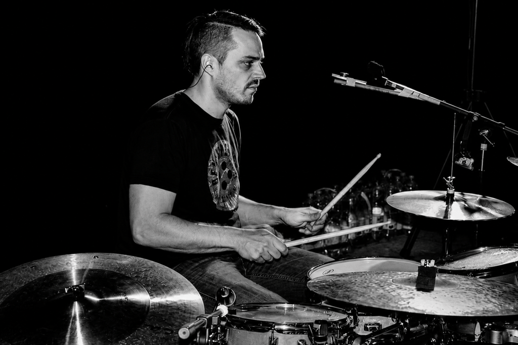 marco am Drumset, hält zwei sticks in der hand am schlagzeug